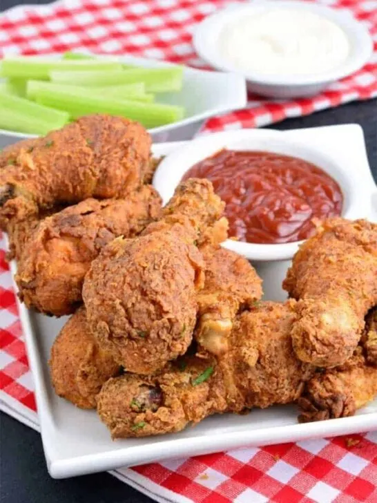 Crispy fried Chicken drumsticks with ketchup and celery sticks
