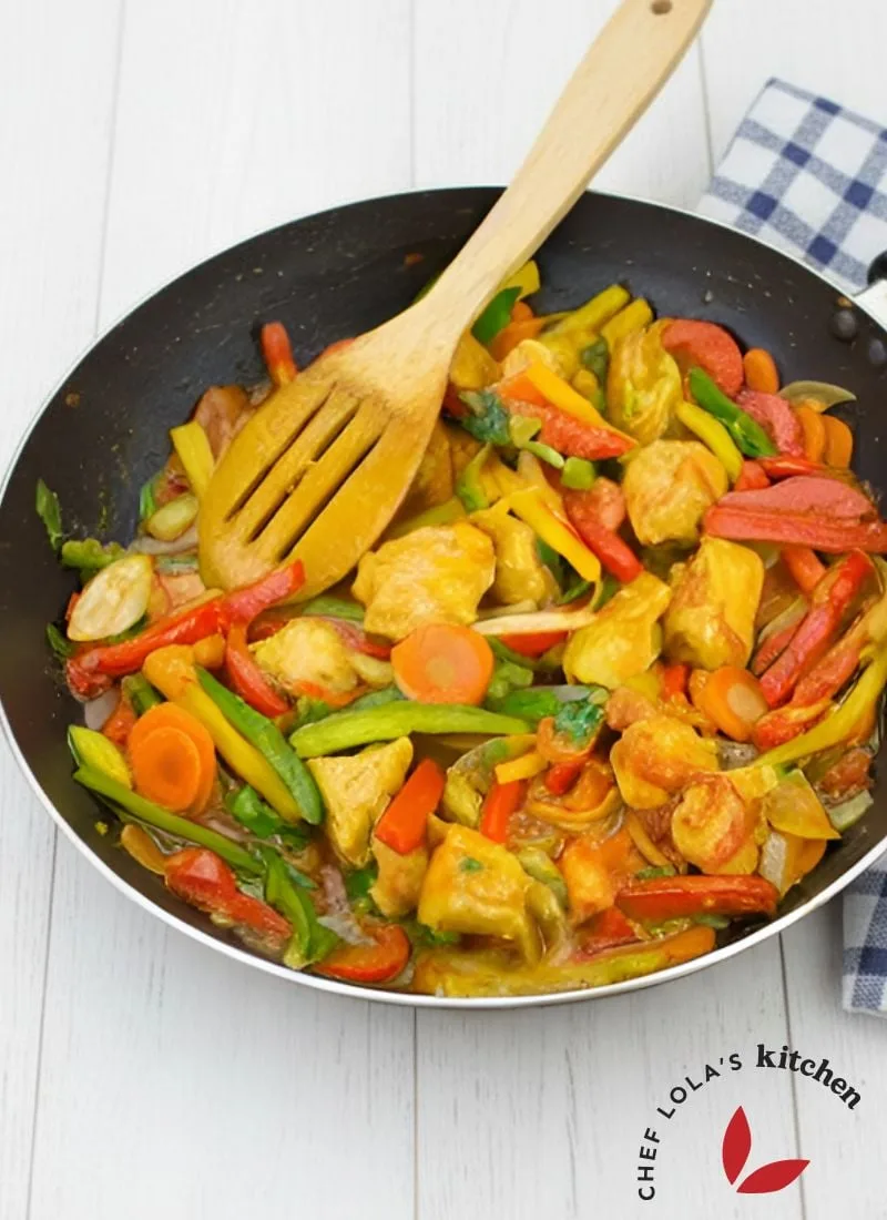 Colorful chicken stir-fry with bell peppers and onions in a skillet.