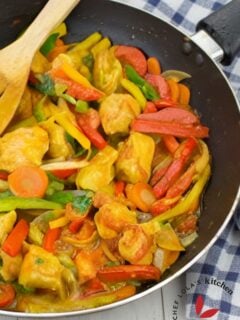 Colorful chicken stir-fry with bell peppers and onions in a skillet.