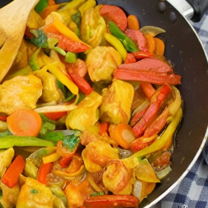 Colorful chicken stir-fry with bell peppers and onions in a skillet.