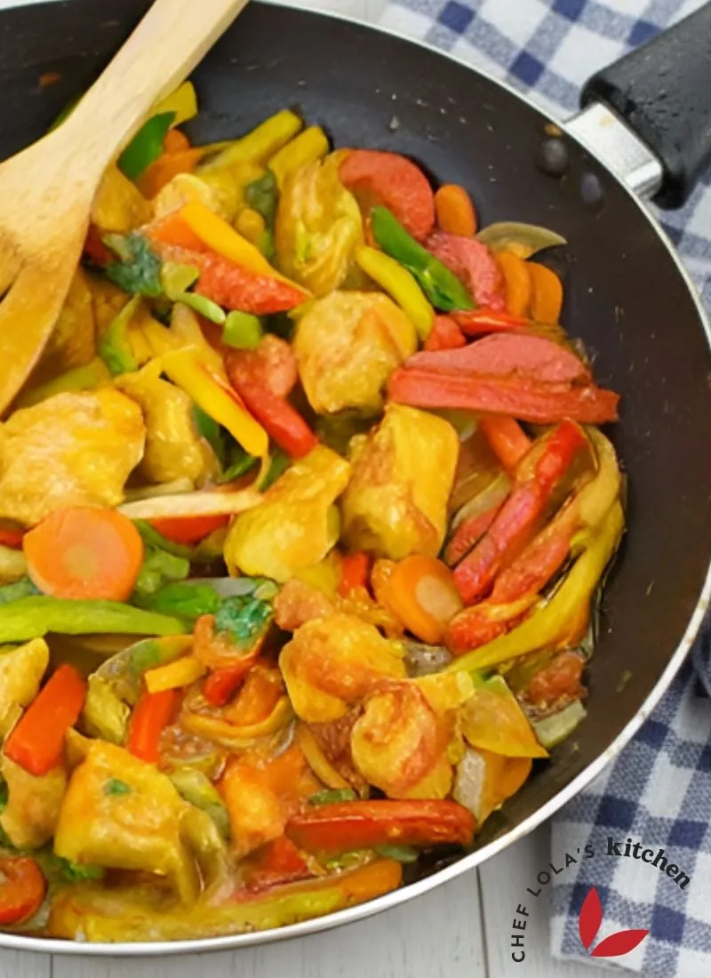 Colorful chicken stir-fry with bell peppers and onions in a skillet.