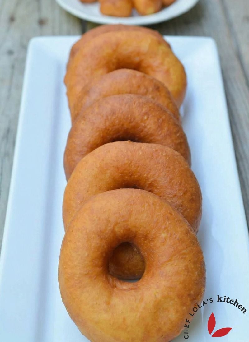 Fluffy yeast-raised donuts arranged on a plate with a shiny glaze