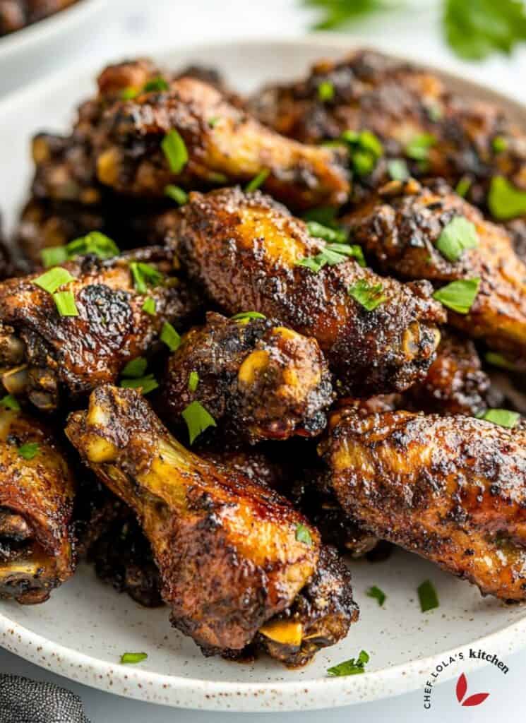 Jamaican Jerk Chicken wings coated in a spicy glaze, grilled with a slight char and served on a plate