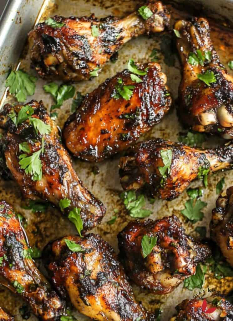 Jamaican Jerk Chicken wings in a baking pan garnished with fresh parsley leaves.