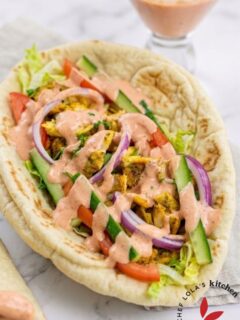 Shawarma served in pita bread with cucumbers, tomatoes, onions, and dressing