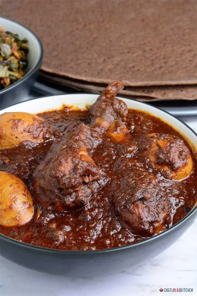 A bowl of Ethiopian Doro Wat chicken stew served with boiled eggs and spices.