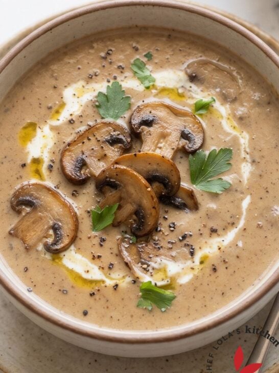 Homemade cream of mushroom soup in a bowl with a spoon, crusty bread and a linen napkin
