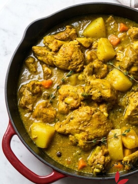 Delicious homemade Jamaican curry chicken cooked in a skillet and garnished with parsley.