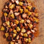 Homemade diced chicken al pastor served on a platter with grilled pineapple.