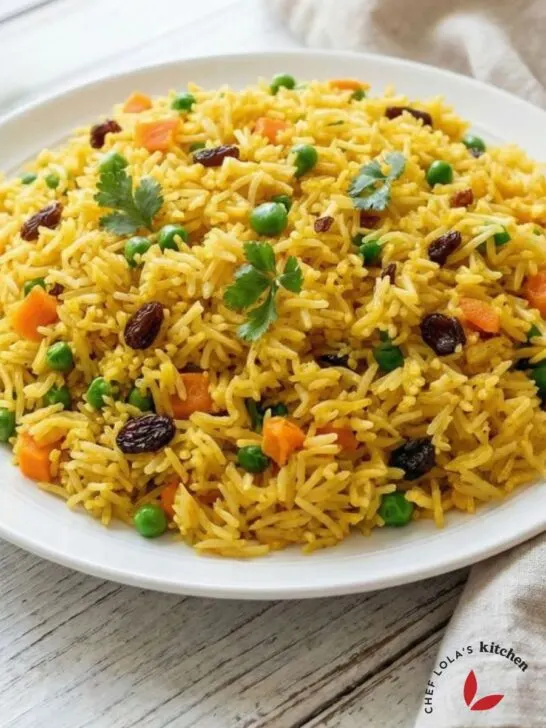 Buttery saffron rice pilaf with separate fluffy grains, garnished with fresh veggies,