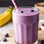 A creamy and delicious blueberry banana smoothie in a clear glass.