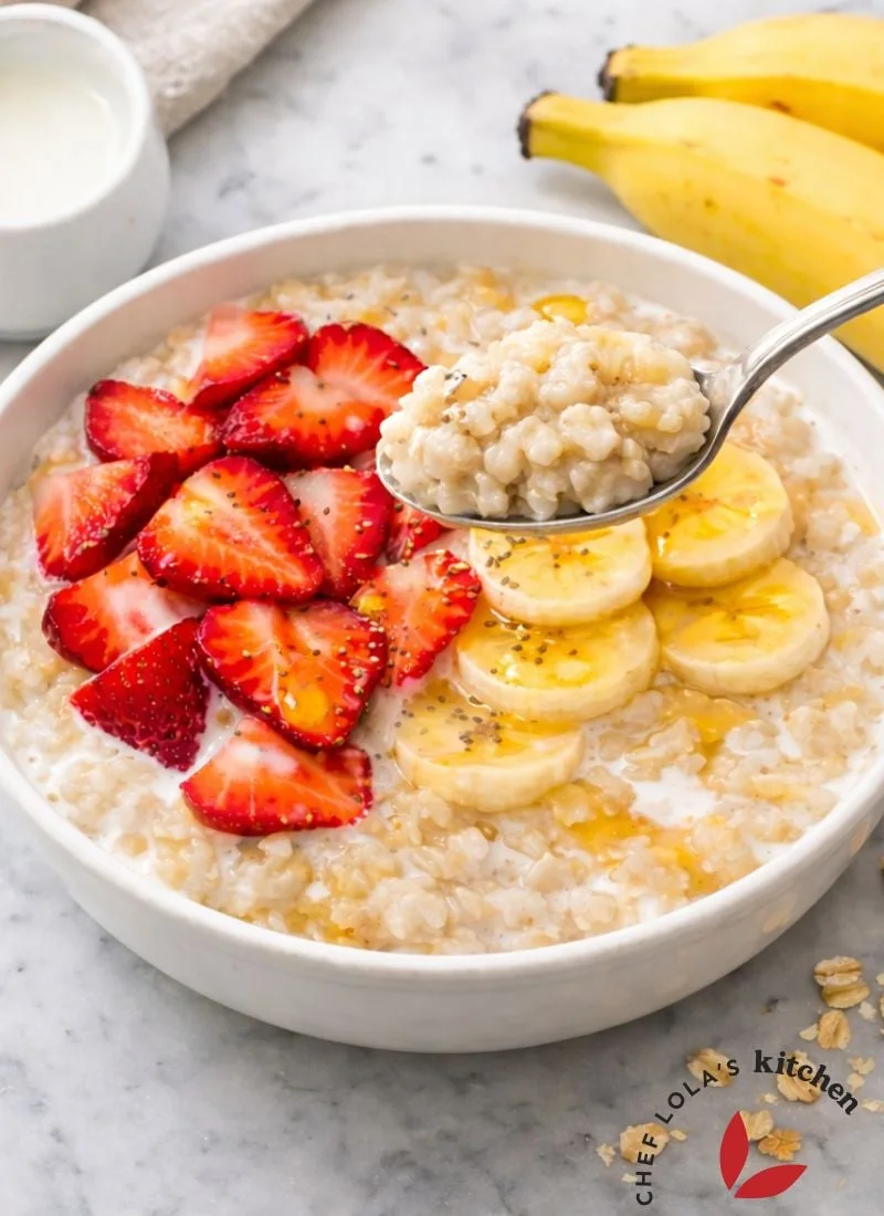 A breakfast spread featuring oatmeal porridge with banana slices and berries.