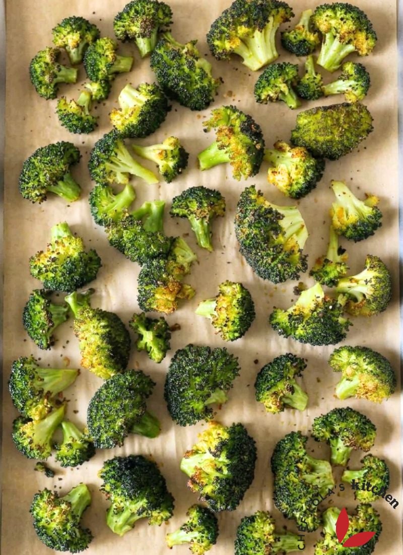 Homemade roasted broccoli florets arranged on a baking sheet.