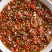 Close-up of chunky fresh salsa filled with tomatoes, onions, peppers, and herbs.