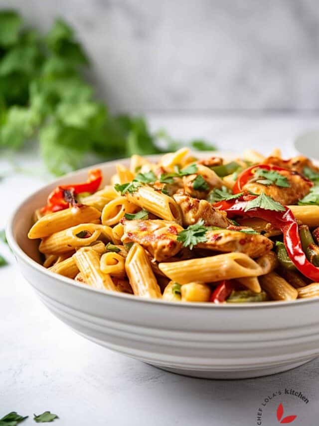 Delicious Creamy Jerk Chicken Jamaican Rasta Pasta served in a white bowl.