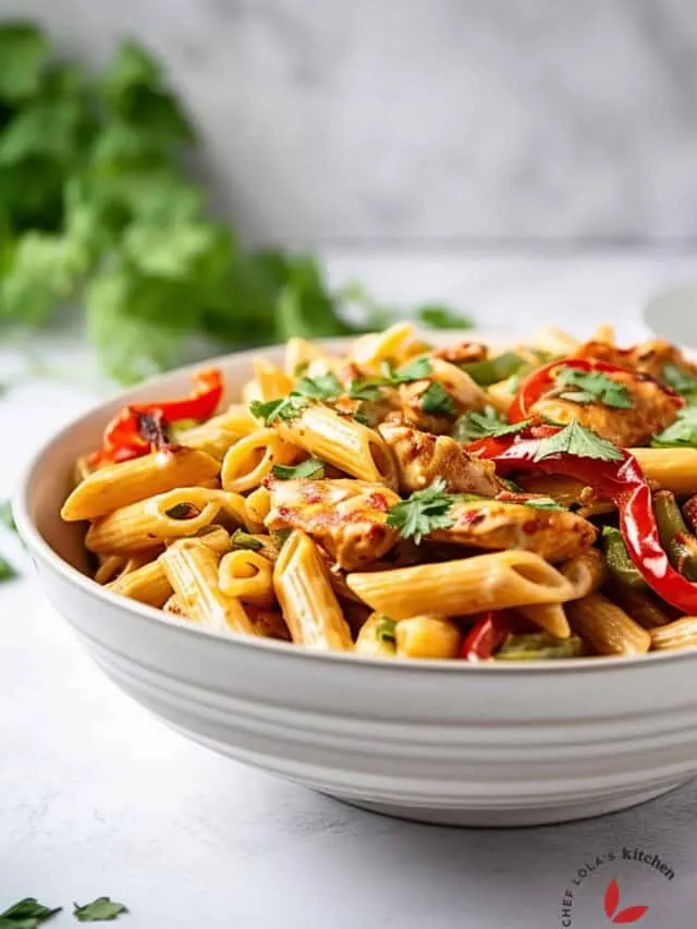 Delicious Creamy Jerk Chicken Jamaican Rasta Pasta served in a white bowl.