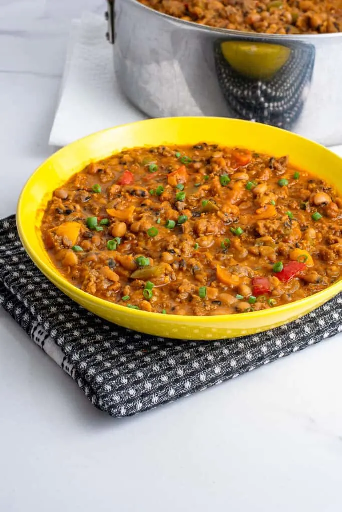 A colorful and enticing plate of beans mixed with savory ground beef, garnished with fresh herbs.