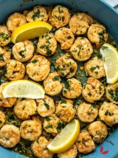 Shrimp scampi beautifully garnished with lemon wedges and parsley.