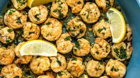 Shrimp scampi beautifully garnished with lemon wedges and parsley.