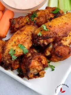 Crispy air fried wings served in a plate with veggies