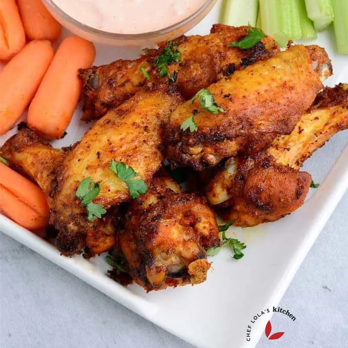 Crispy air fried wings served in a plate with veggies