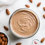 Top-down view of creamy homemade almond butter in a glass jar
