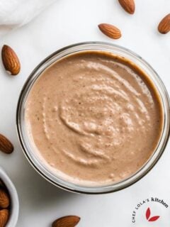 Top-down view of creamy homemade almond butter in a glass jar
