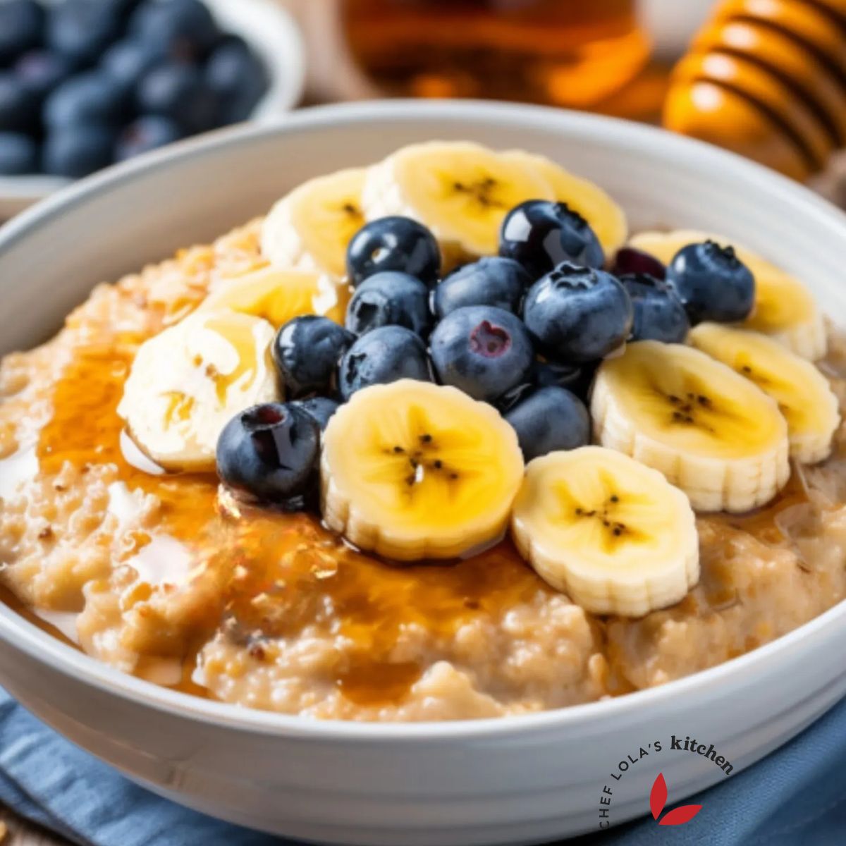 A hearty bowl of oatmeal porridge topped with banana slices, berries and honey