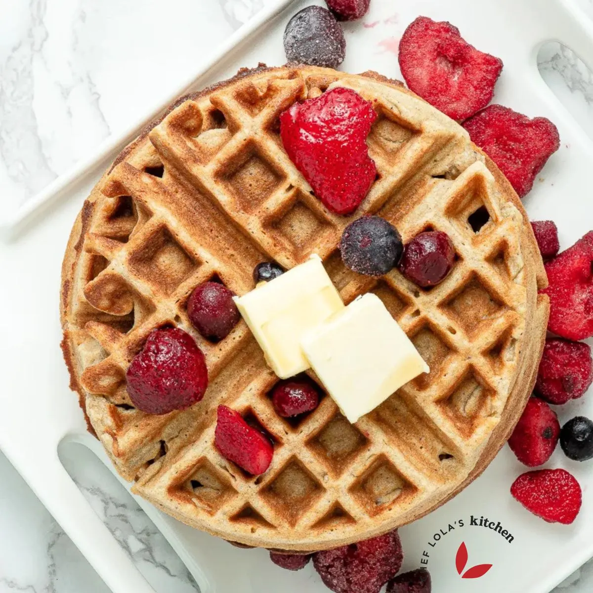 Homemade Buttermilk waffles served in a plate and beautifully garnished with fruits and butter slices