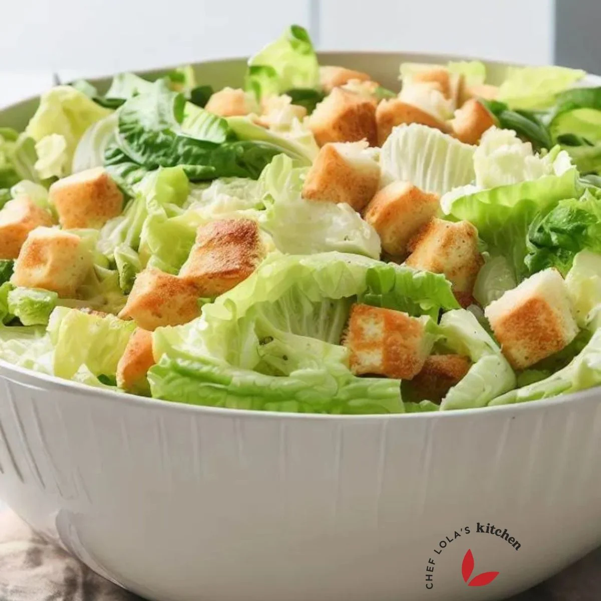 A bowl of Caesar salad made with lettuce and croutons