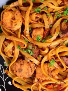 Jambalaya pasta seved in a black bowl garnished with parsley