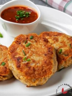 Golden brown chicken patties served with a dip on a plate