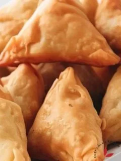 deep fried crispy samosas stacked on a tray