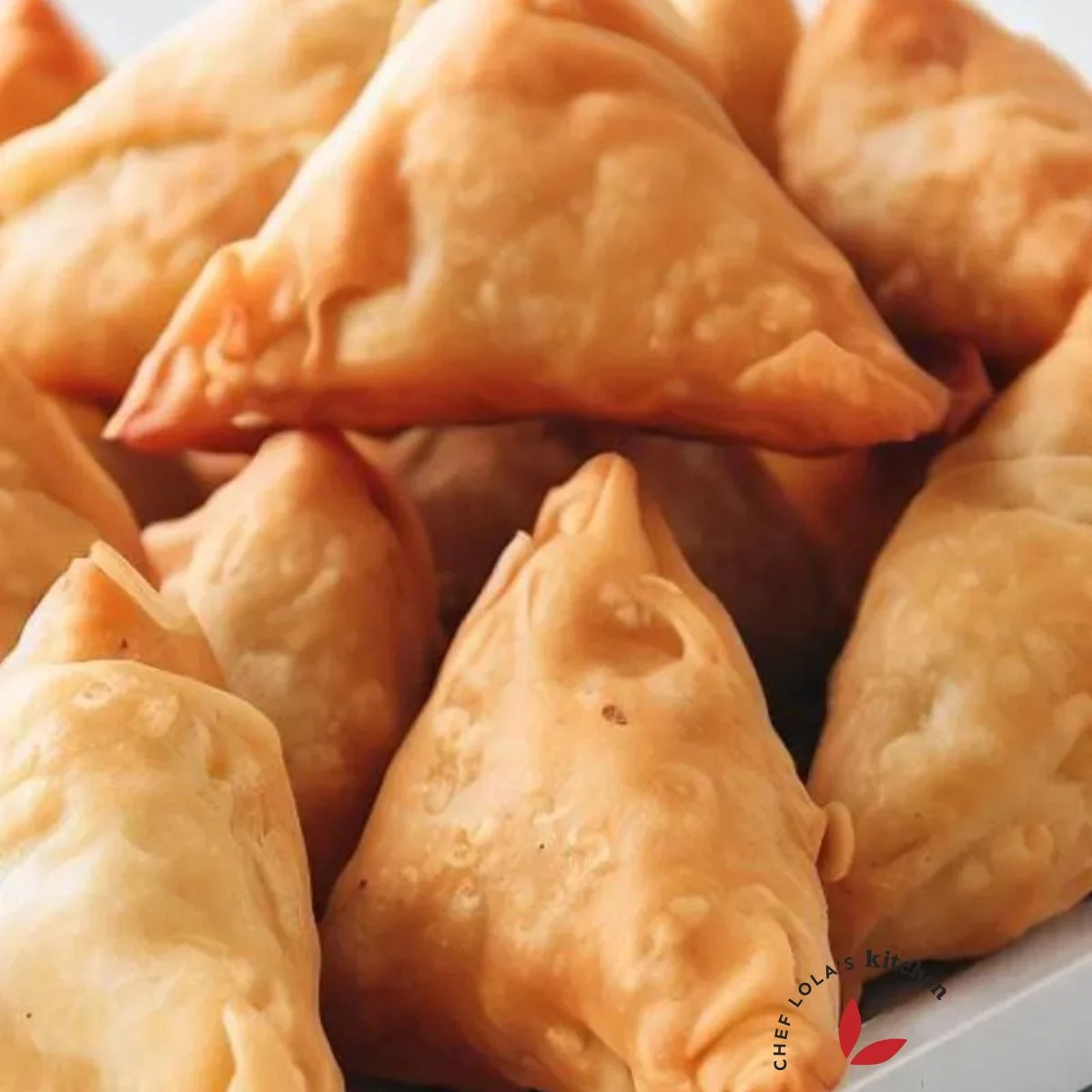 deep fried crispy samosas stacked on a tray