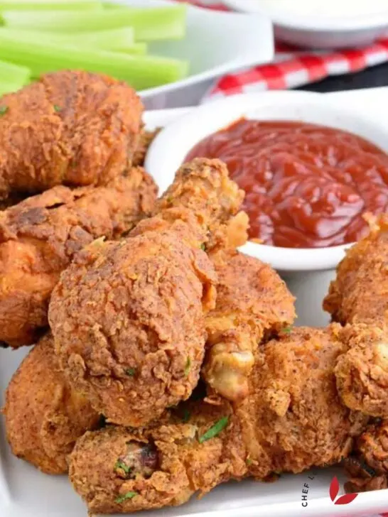 Crispy fried Chicken drumsticks with ketchup and celery sticks