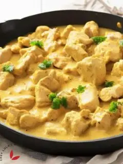 Delicious chicken curry well garnished with cilantro in a skillet