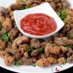 Deep fried chicken Gizzards plated inside a bowl with dipping sauce