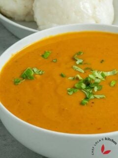 Gbegiri soup served in a bowl and garnished with herbs.