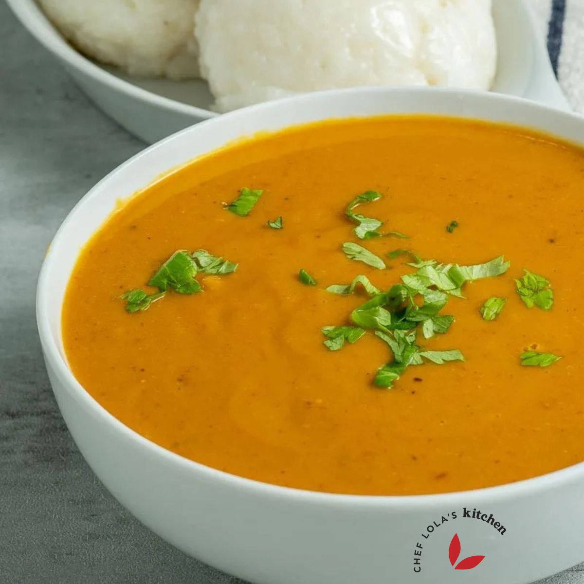 Gbegiri soup served in a bowl and garnished with herbs.