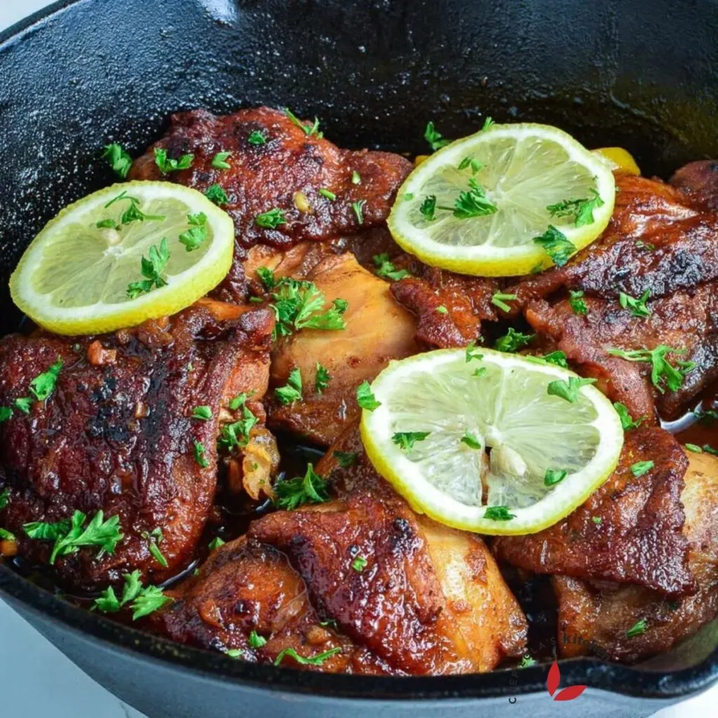 Crispy Honey Garlic Chicken Thighs, garnished with lemon slices and parsley