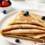 Homemade Crepes beautifully arranged on a plate.