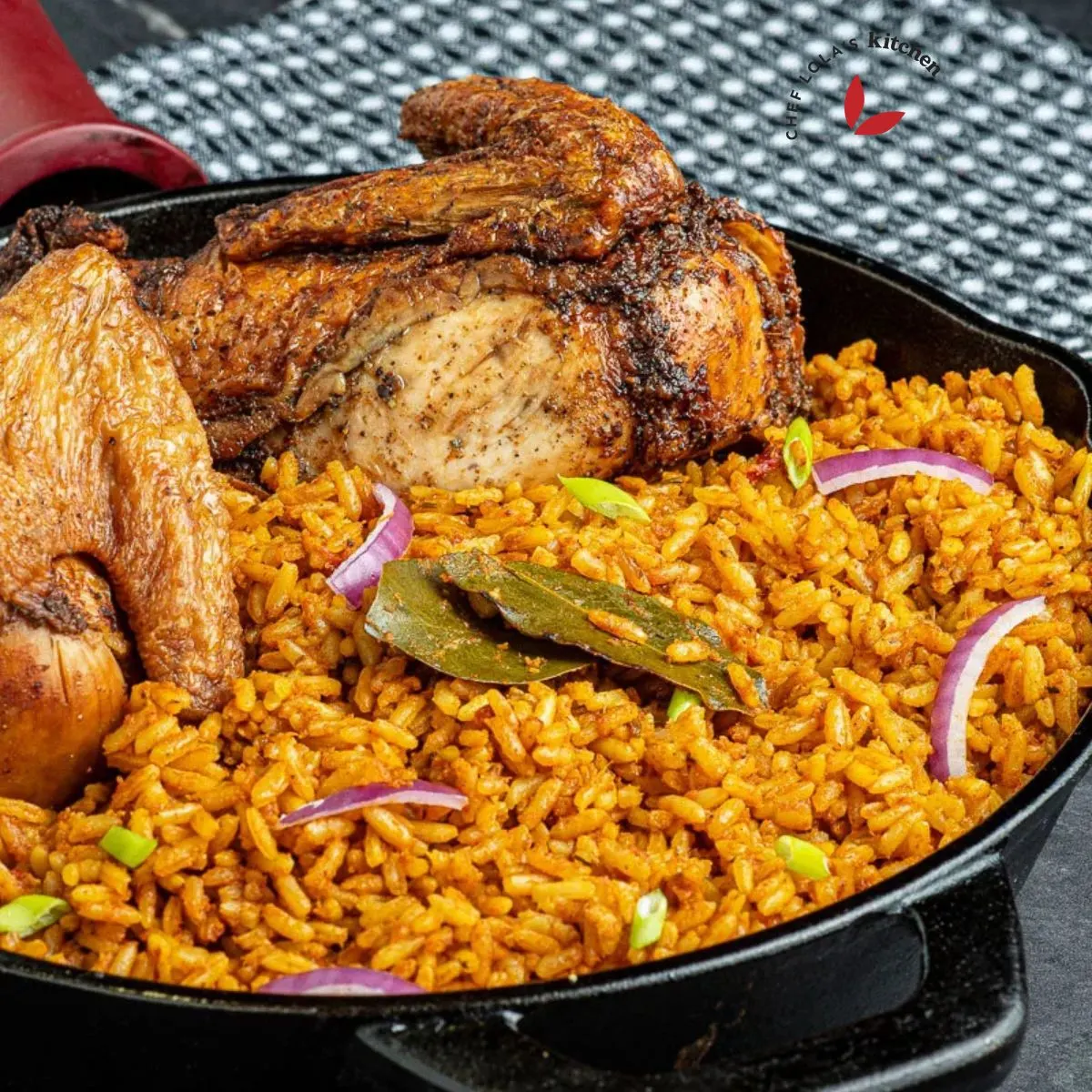 Jollof Rice with roasted chicken, garnished with bay leaves and red onion.
