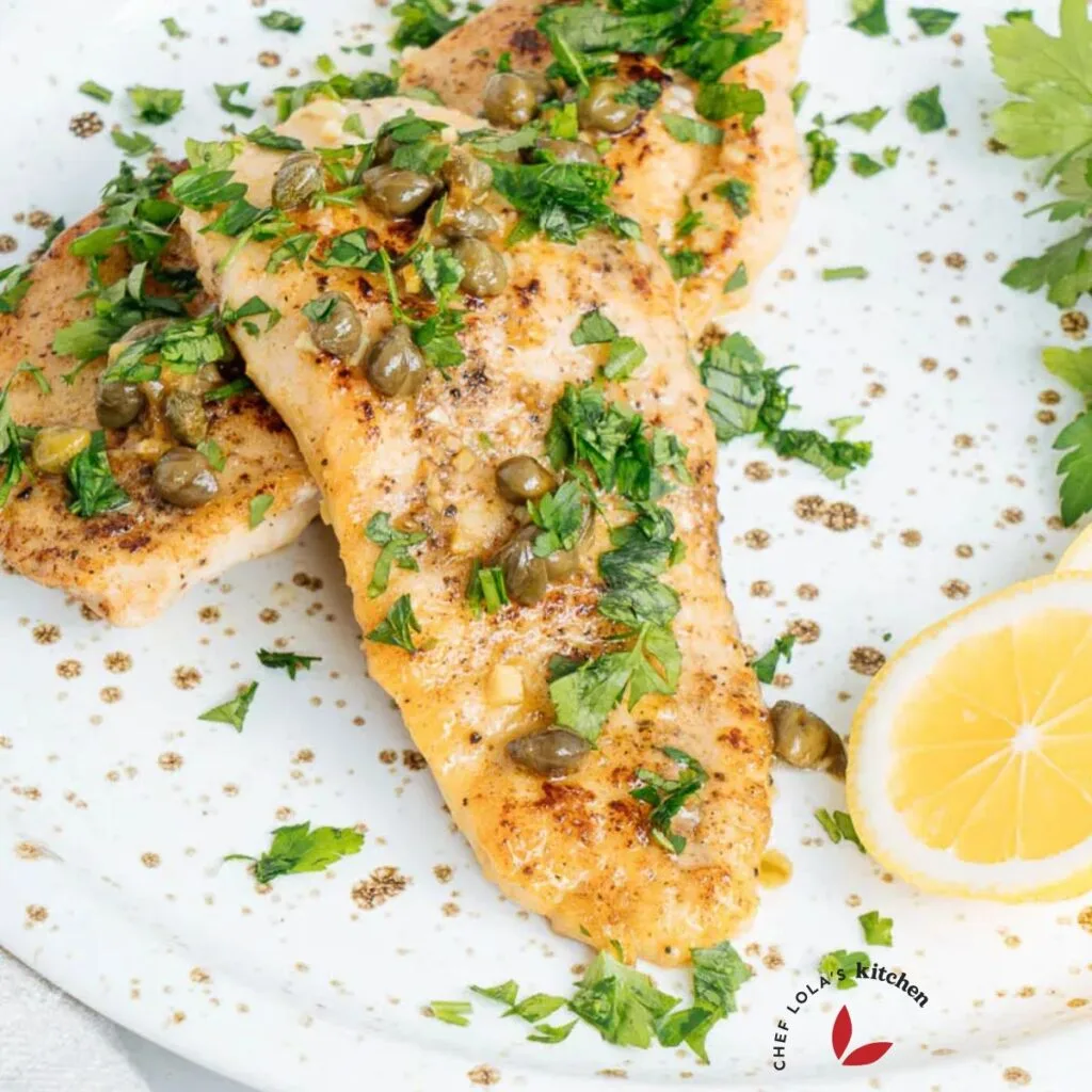 Chicken piccata topped with capers and parsley