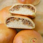 Freshly baked Meat Buns sliced into two to show the delicious meat filling