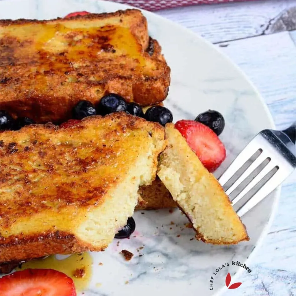 Oven baked french toast garnished with berries - showing how soft the interior is