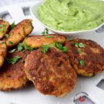 Shrimp cakes served in a large white plate and garnished with parsley.