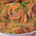 Smothered Chicken filled with gravy in a pan