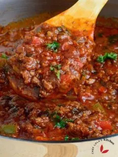 Close look on Pasta sauce scooped with a wooden spoon from a pot