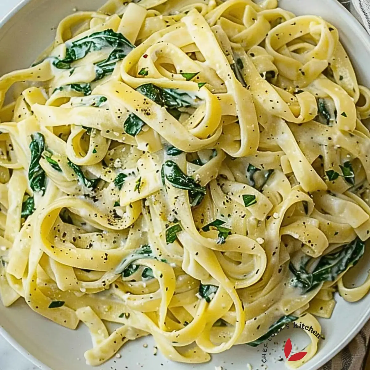 Bowl of creamy spinach pasta garnished with parmesan, perfect for a quick weeknight dinner.