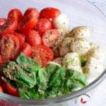 Tomato Mozzarella Salad seasoned with salt, black pepper and oregano in a bowl